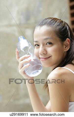 View of a young woman holding a bottle. View Large Photo Image Stock Image - View of a young woman holding a bottle.. Fotosearch