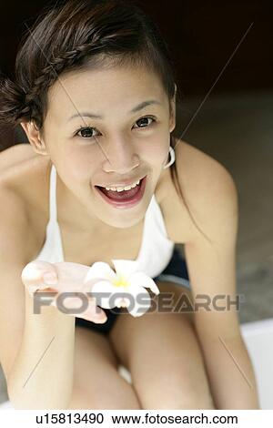 Stock Image - View of a young woman with a flower.. Fotosearch