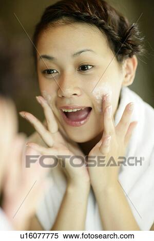 Woman applying a cream on her cheeks. View Large Photo Image Stock Photography - Woman applying a cream on her cheeks.. Fotosearch