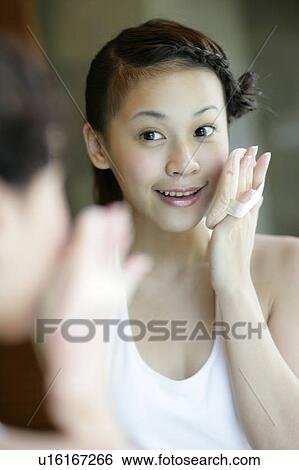 Stock Photograph - Woman applying powder puff on her cheeks.. Fotosearch