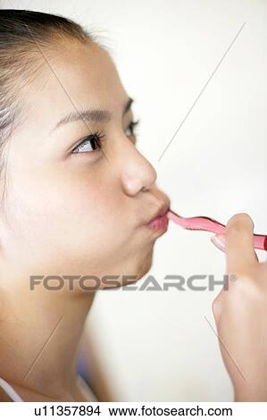 Woman brushing her teeth. View Large Photo Image Picture - Woman brushing her teeth.. Fotosearch