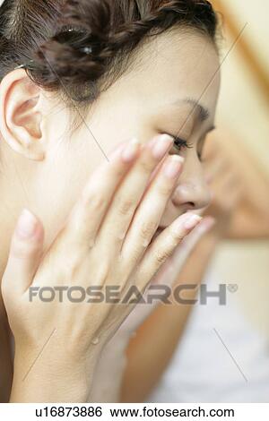 Stock Photograph - Woman washing her face.. Fotosearch