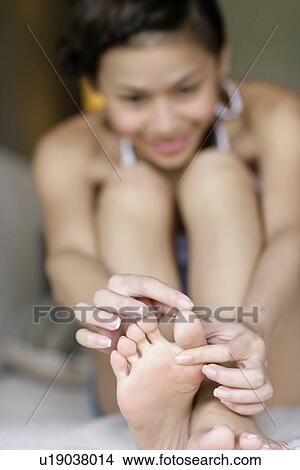 Blurred view of a young woman holding toenail. View Large Photo Image Picture - Blurred view of a young woman holding toenail.. Fotosearch