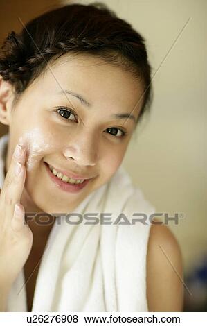 Portrait of a young woman applying cream on face. View Large Photo Image Stock Photo - Portrait of a young woman applying cream on face.. Fotosearch