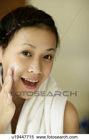 Portrait of a young woman applying cream. View Large Photo Image Stock Photography - Portrait of a young woman applying cream.. Fotosearch