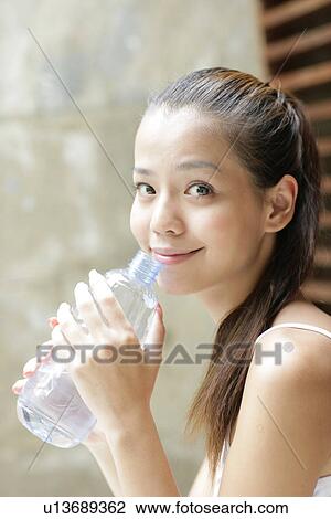 Portrait of a young woman holding water bottle. View Large Photo Image Stock Image - Portrait of a young woman holding water bottle.. Fotosearch