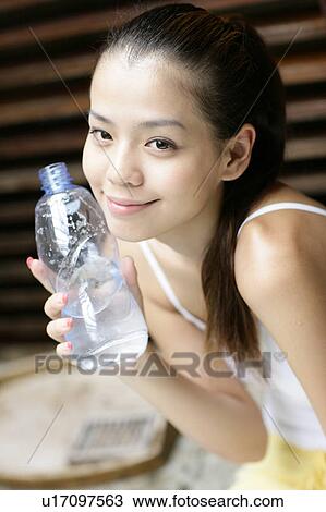 Portrait of a young woman holding water bottle. View Large Photo Image Stock Image - Portrait of a young woman holding water bottle.. Fotosearch