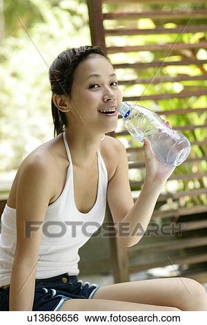 Portrait of a young woman holding water bottle. View Large Photo Image Stock Photograph - Portrait of a young woman holding water bottle.. Fotosearch