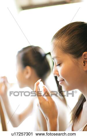 Profile of young woman holding deodorant. View Large Photo Image Stock Image - Profile of young woman holding deodorant.. Fotosearch