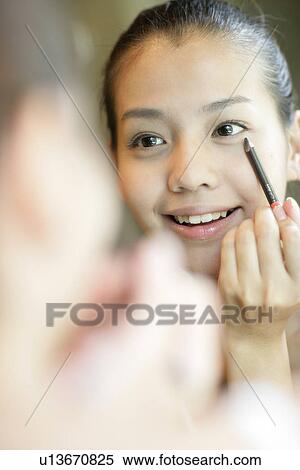 View of a young woman applying an eyebrow pencil. View Large Photo Image Stock Photography - View of a young woman applying an eyebrow pencil.. Fotosearch