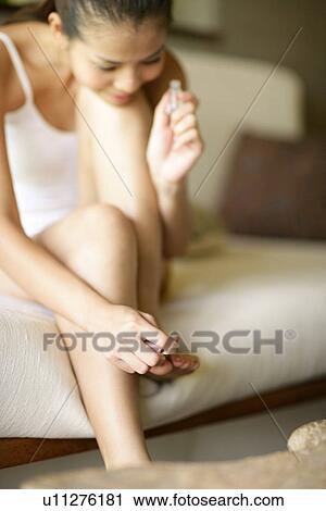 View of a young woman applying nail polish. View Large Photo Image Stock Image - View of a young woman applying nail polish.. Fotosearch