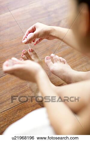 View of a young woman applying nail paint remover. View Large Photo Image Stock Photograph - View of a young woman applying nail paint remover.. Fotosearch
