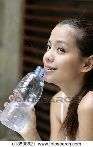 View of a young woman holding water bottle. View Large Photo Image Stock Image - View of a young woman holding water bottle.. Fotosearch