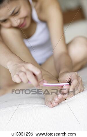 View of a young woman shaping nails. View Large Photo Image Stock Photography - View of a young woman shaping nails.. Fotosearch