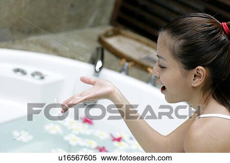 View of a young woman sitting beside a bathtub. View Large Photo Image Stock Photography - View of a young woman sitting beside a bathtub.. Fotosearch