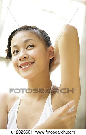 View of a young woman spraying deodorant on underarm. View Large Photo Image Stock Image - View of a young woman spraying deodorant on underarm.. Fotosearch