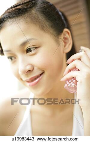 Young woman holding spray bottle in hand. View Large Photo Image Stock Image - Young woman holding spray bottle in hand.. Fotosearch