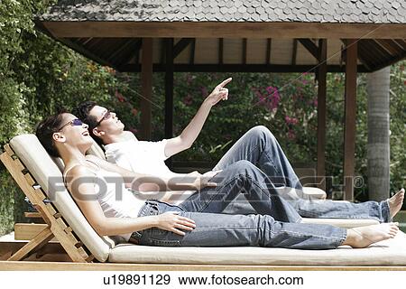 Couple lying on a reclining chair. View Large Photo Image Stock Photo - Couple lying on a reclining chair.. Fotosearch