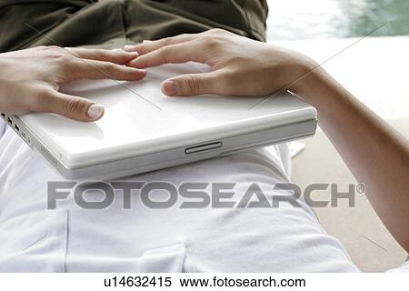 Man lying with a laptop on his chest. View Large Photo Image Stock Photography - Man lying with a laptop on his chest.. Fotosearch