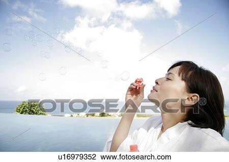 Profile of a young woman blowing bubbles. View Large Photo Image Stock Image - Profile of a young woman blowing bubbles.. Fotosearch