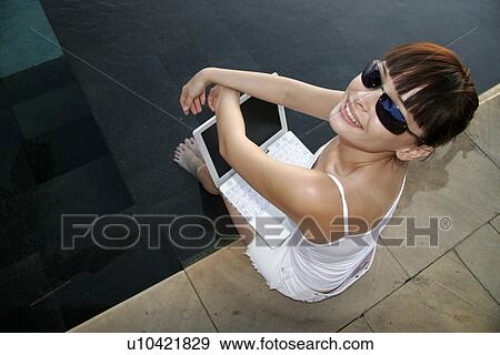 Stock Photo - Top view of a woman sitting with a laptop.. Fotosearch