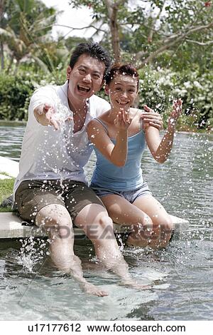 View of a couple enjoying in water. View Large Photo Image Stock Image - View of a couple enjoying in water.. Fotosearch