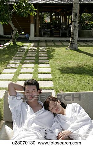 View of a couple lying on deck chairs. View Large Photo Image Stock Image - View of a couple lying on deck chairs.. Fotosearch