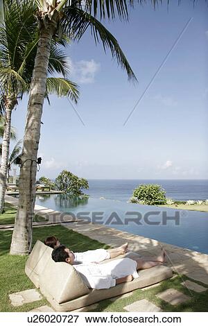 View of a couple lying on deck chairs. View Large Photo Image Stock Photo - View of a couple lying on deck chairs.. Fotosearch