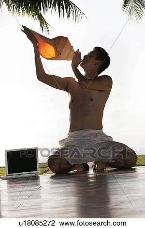 View of a man blowing shell. View Large Photo Image Stock Image - View of a man blowing shell.. Fotosearch