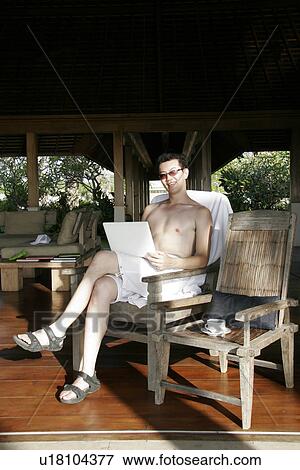 Stock Photo - View of a man reading newspaper while sitting.. Fotosearch