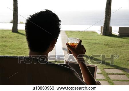 View of a man sitting on a chair. View Large Photo Image Stock Image - View of a man sitting on a chair.. Fotosearch