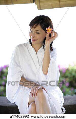 Stock Image - View of a woman holding a flower.. Fotosearch