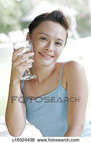 Stock Photo - View of a woman holding glass of water.. Fotosearch