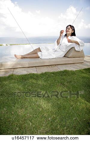 Stock Photo - View of a woman lying on a deck chair.. Fotosearch