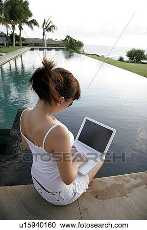 View of a woman sitting with a laptop. View Large Photo Image Stock Image - View of a woman sitting with a laptop.. Fotosearch