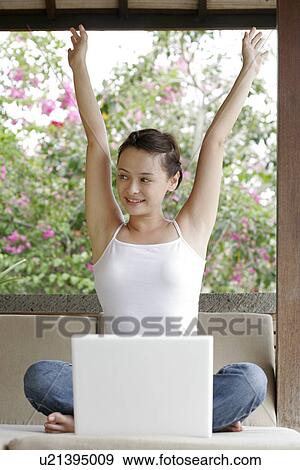 View of a woman sitting with a laptop. View Large Photo Image Stock Photo - View of a woman sitting with a laptop.. Fotosearch