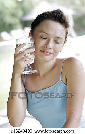 Stock Photo - View of a young woman holding goblet.. Fotosearch