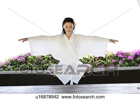 Stock Image - View of a young woman performing yoga in a room.. Fotosearch