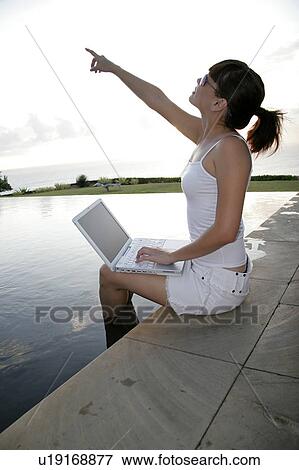 View of a young woman pointing towards sky. View Large Photo Image Stock Photo - View of a young woman pointing towards sky.. Fotosearch
