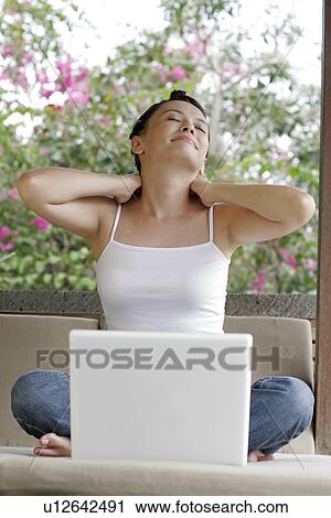 Stock Image - View of a young woman stretching.. Fotosearch