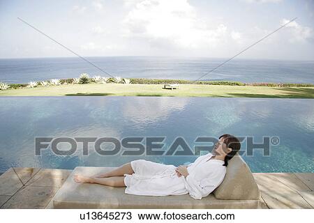 Young woman lying besides a swimming pool. View Large Photo Image Stock Image - Young woman lying besides a swimming pool.. Fotosearch