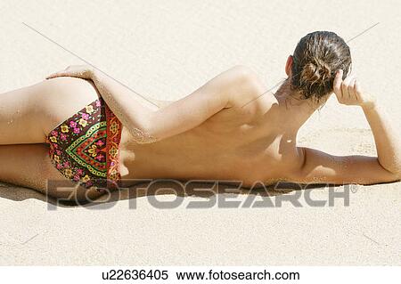 Rear view of a topless woman lying on a beach. View Large Photo Image Stock Photography - Rear view of a topless woman lying on a beach.. Fotosearch