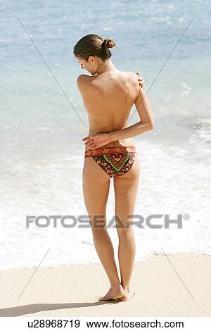 Rear view of a topless woman standing on a beach. View Large Photo Image Stock Photo - Rear view of a topless woman standing on a beach.. Fotosearch