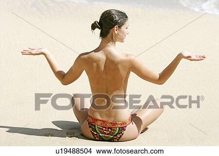 Rear view of a woman exercising on a beach. View Large Photo Image Picture - Rear view of a woman exercising on a beach.. Fotosearch