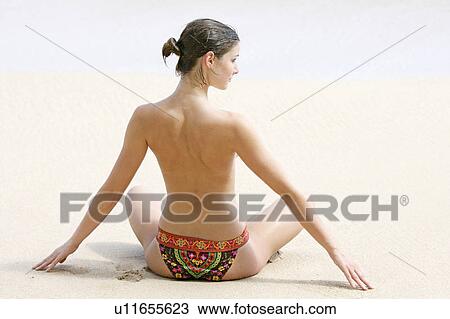 Rear view of a woman exercising on a beach. View Large Photo Image Stock Image - Rear view of a woman exercising on a beach.. Fotosearch