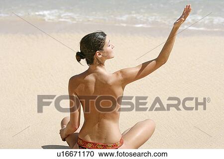 Rear view of a woman exercising on a beach. View Large Photo Image Stock Image - Rear view of a woman exercising on a beach.. Fotosearch