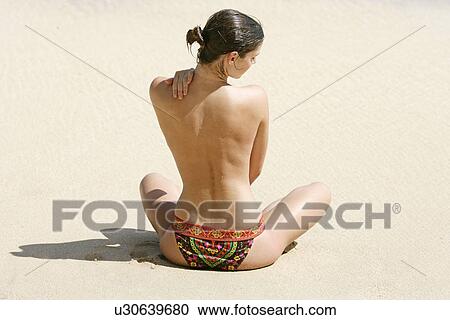 Rear view of a woman exercising on a beach. View Large Photo Image Stock Image - Rear view of a woman exercising on a beach.. Fotosearch