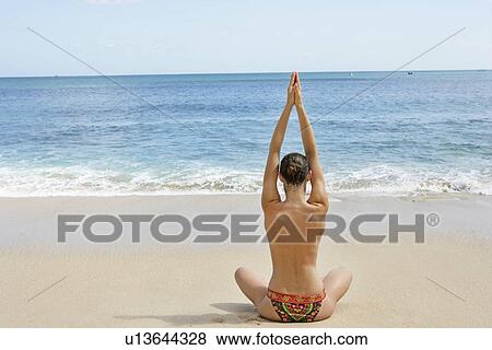 Rear view of a woman exercising on a beach. View Large Photo Image Stock Photo - Rear view of a woman exercising on a beach.. Fotosearch