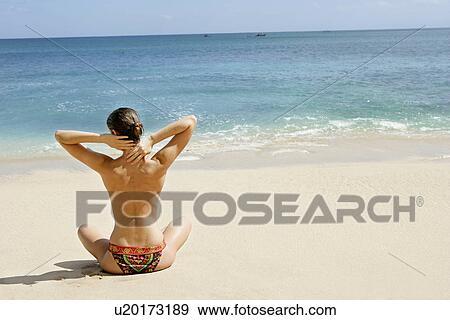 Rear view of a woman exercising on a beach. View Large Photo Image Stock Photo - Rear view of a woman exercising on a beach.. Fotosearch