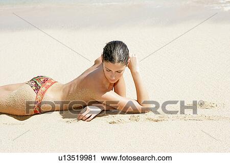 View of a topless woman lying on a beach. View Large Photo Image Stock Image - View of a topless woman lying on a beach.. Fotosearch